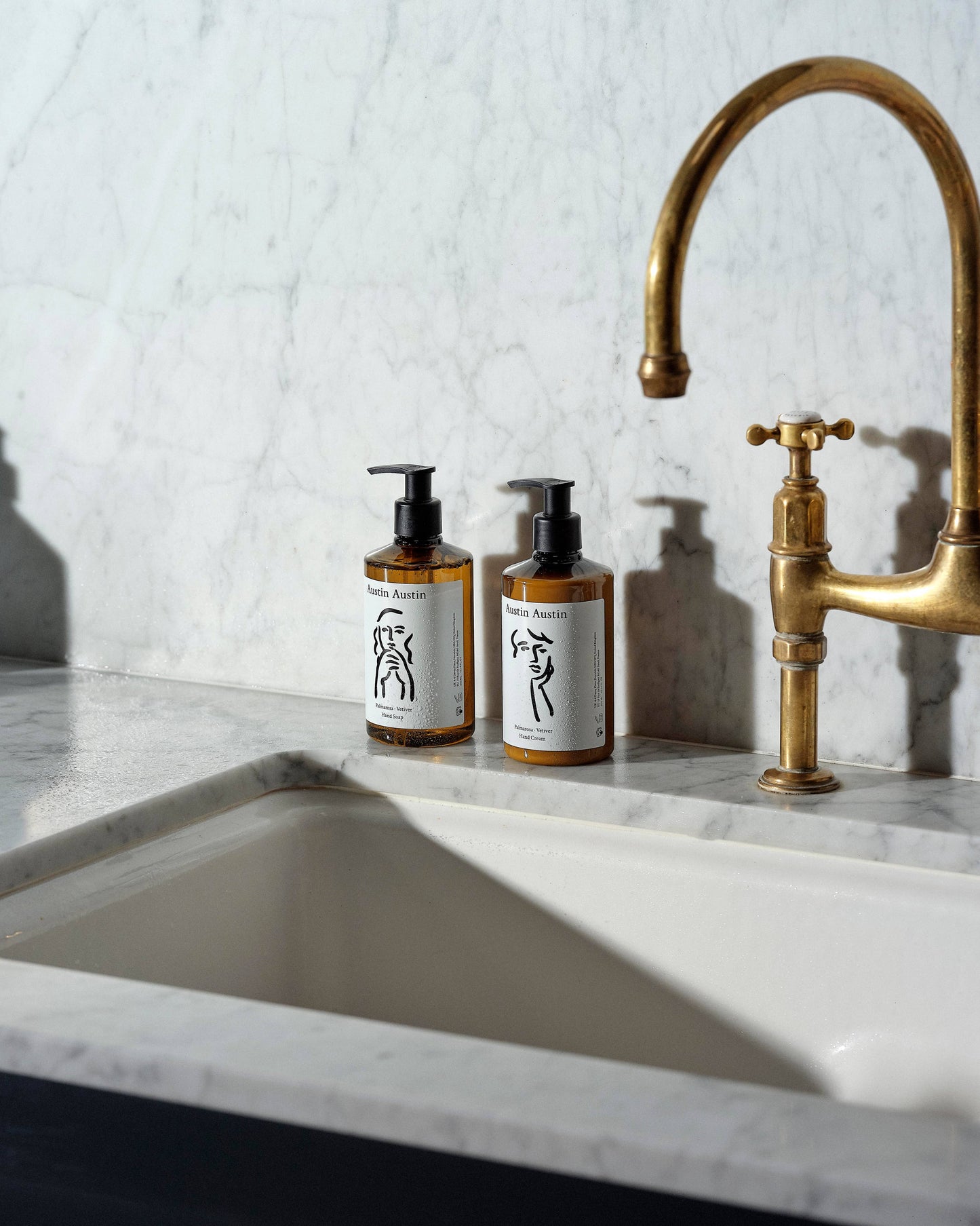 Austin Austin Palmarosa and Vetiver Hand Cream 300ml bottle alongside the matching Hand Soap 300ml, arranged on next to a kitchen sink