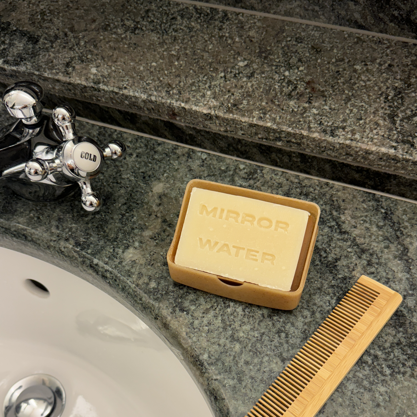 Mirror Water BUTTER BRICK shea butter bar sat in a soap tray on a marble surface next to a sink