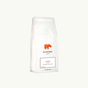 Kiss the Hippo organic whole bean coffee in a white nitrogen-flushed bag featuring a red hippo logo and Donna blend label.