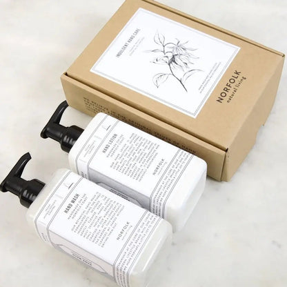 Norfolk Natural Living Indulgent Hand Care Set featuring Coastal Walks hand wash and lotion in white pump bottles with a gift box.