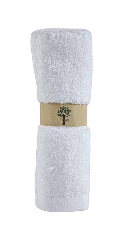 Re:gn organic bamboo face cloths in a plush white texture, rolled and secured with a sustainable paper band.