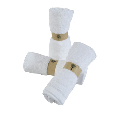 Re:gn organic bamboo face cloths in white, rolled and secured with eco-friendly paper bands.
