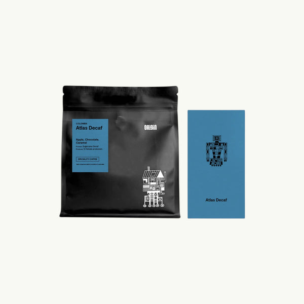 Origin Coffee Atlas Decaf whole bean coffee in a black pouch with a blue information card featuring robot graphic design