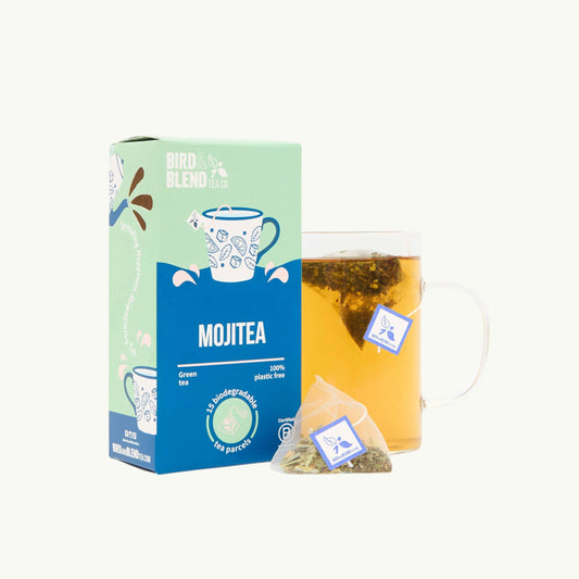 Bird and Blend MojiTEA green tea box with a glass mug of brewed tea and a plastic-free biodegradable tea bag