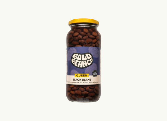 BRiMM Queen Black Beans in a 570g glass jar with a yellow lid and purple label featuring earthy, glossy beans.
