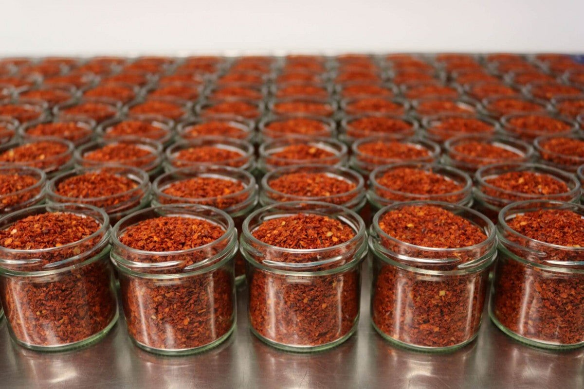 Steenbergs organic Aleppo chilli flakes in small glass jars, featuring a deep red colour and smoky, mild spice profile.