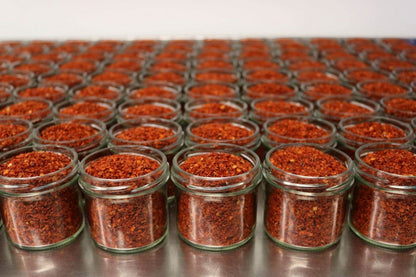 Steenbergs organic Aleppo chilli flakes in small glass jars, featuring a deep red colour and smoky, mild spice profile.