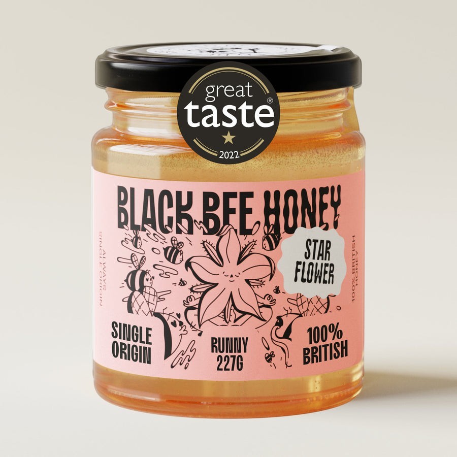 Black Bee Honey Raw Starflower Honey in a 227g glass jar with a Great Taste Award label on a neutral background.