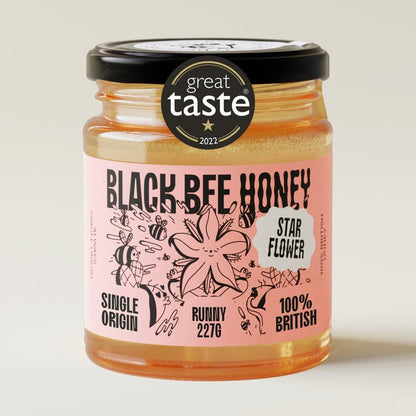 Black Bee Honey Raw Starflower Honey in a 227g glass jar with a Great Taste Award label on a neutral background.