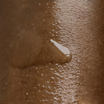 Mirror Water body oil with a non-greasy, satin finish applied to skin, showing a clear, lightweight texture.