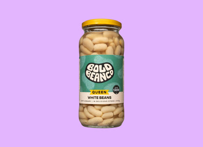 Bold Bean Co Queen white beans in a 570g glass jar with a yellow lid and green label, shown from a different angle.