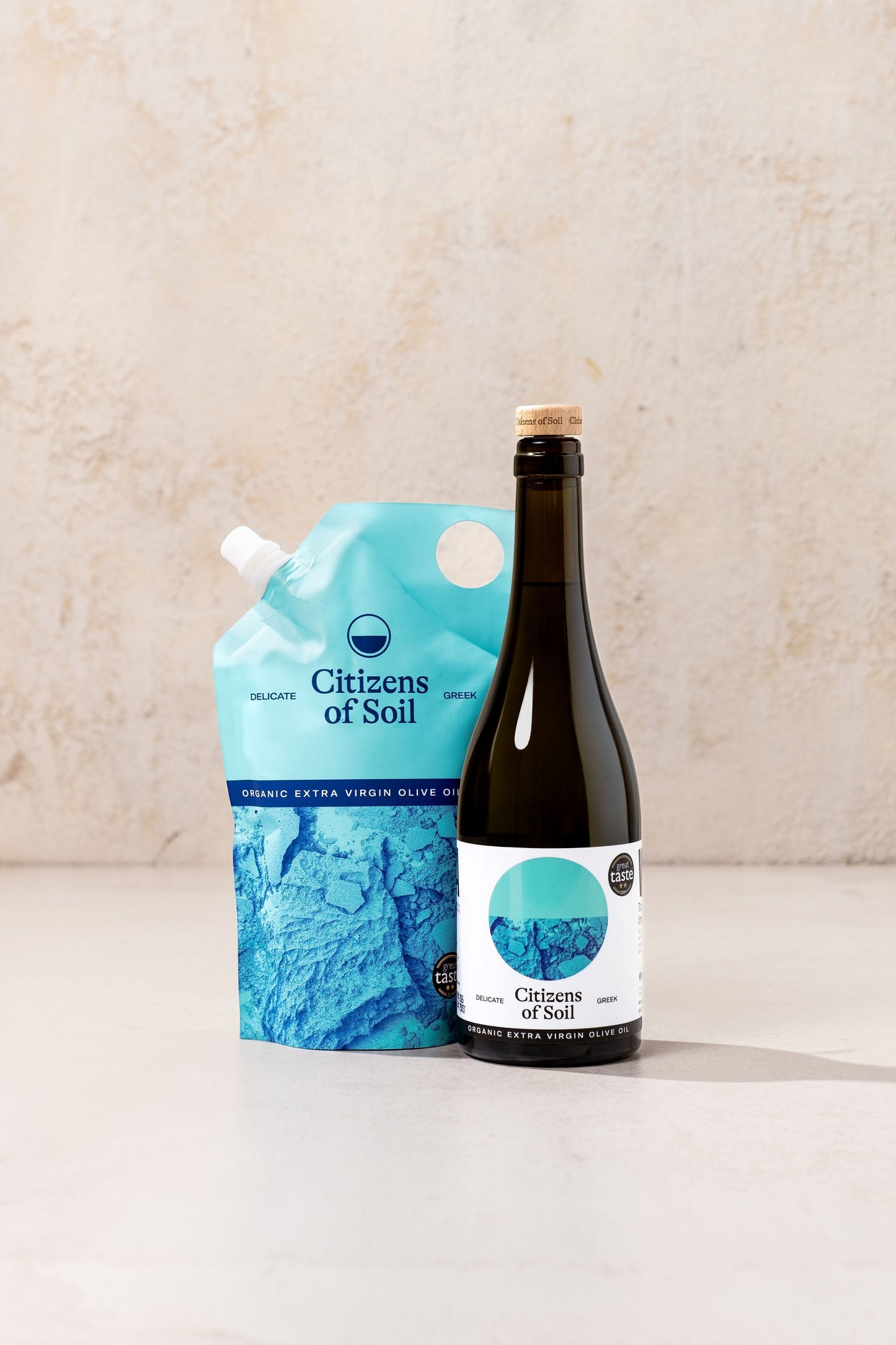 BRiMM Citizens of Soil organic Greek extra virgin olive oil in a dark glass bottle and a blue refill pouch.