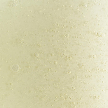 Close-up texture of UpCircle citrusy hand and body wash gel with visible bubbles and a pale yellow hue.