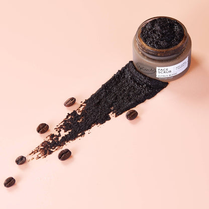 UpCircle coffee and rosehip oil face scrub in a glass jar with a smear of exfoliating mousse on a soft peach background