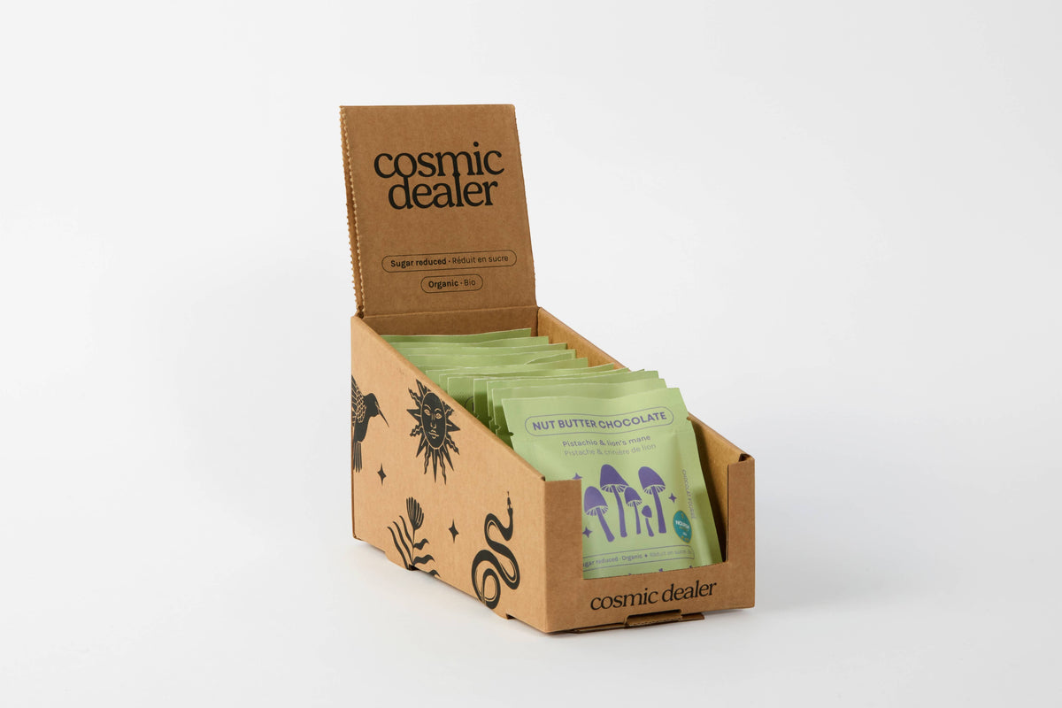 Cosmic Dealer pistachio and lion's mane dark chocolate bars in a branded cardboard display box