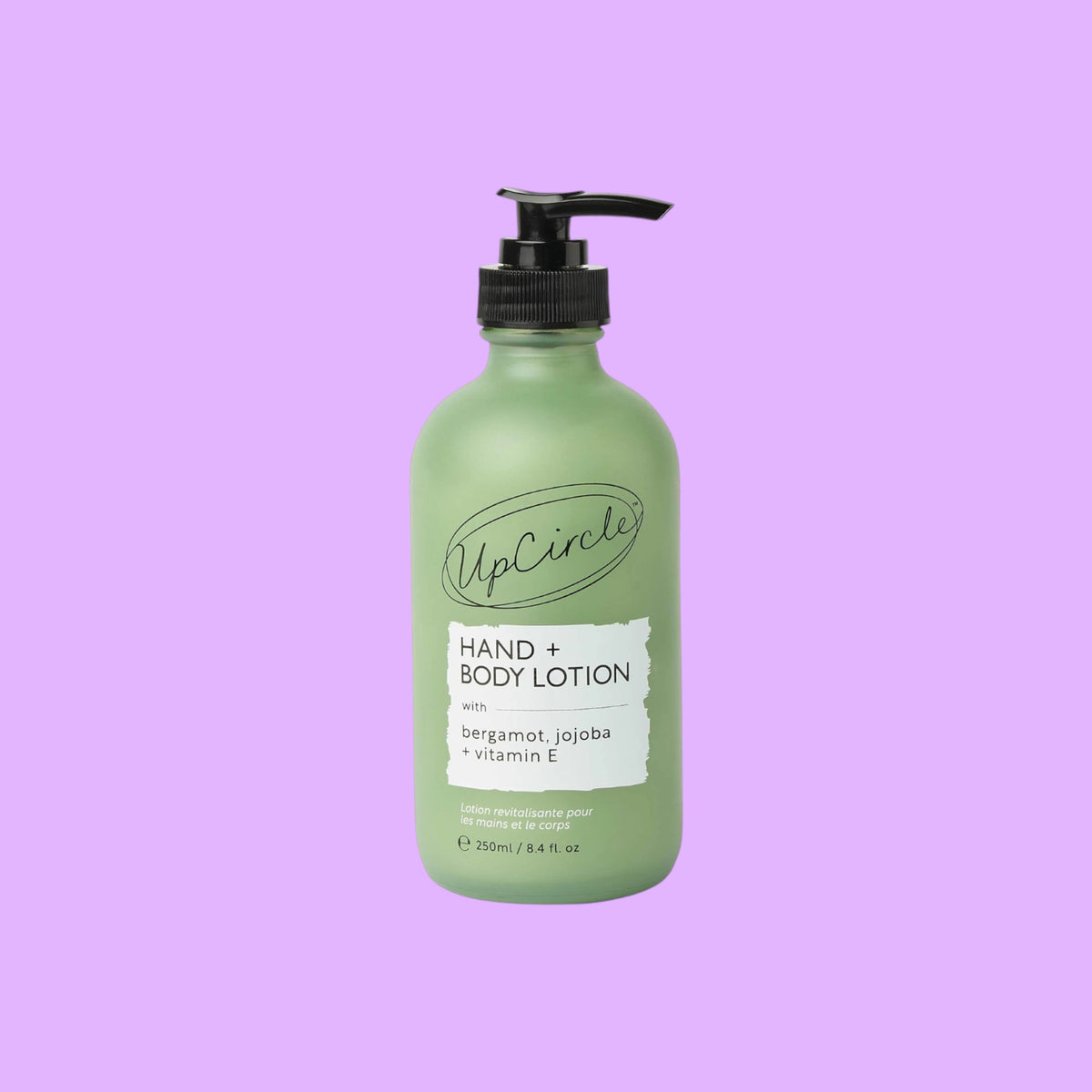UpCircle hand and body lotion in a frosted green glass bottle with a black pump dispenser and bergamot scent label (view 2).