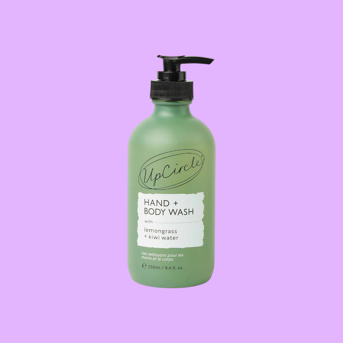 UpCircle Hand & Body Wash in a frosted green glass bottle with a black pump, featuring lemongrass and kiwi fruit water.