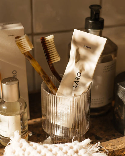 Laro London naturally whitening fluoride-free toothpaste in a recyclable aluminium tube with two toothbrushes.