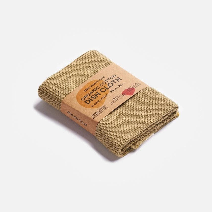 Zero Waste Club organic cotton dish cloth in mustard yellow with a textured weave, packaged in a sustainable cardboard band.