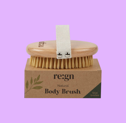 Re:gn natural beechwood body brush with firm sisal bristles and a cotton hand strap resting on its cardboard box