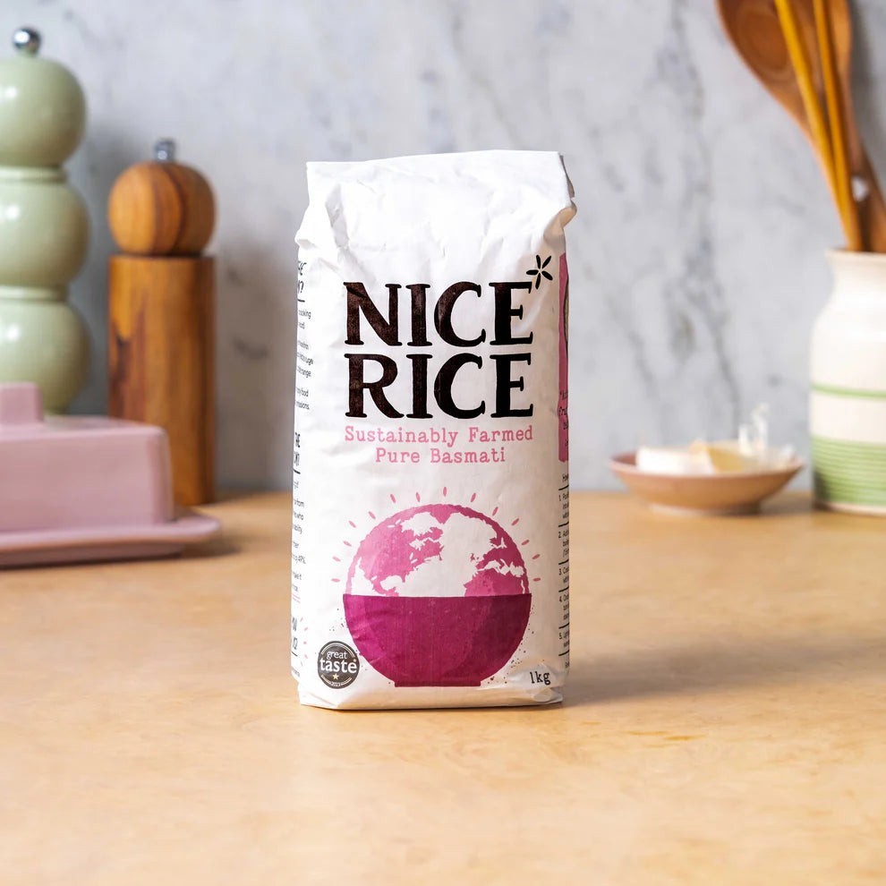 Nice Rice sustainably farmed pure basmati rice in a 1kg white paper bag on a kitchen counter.