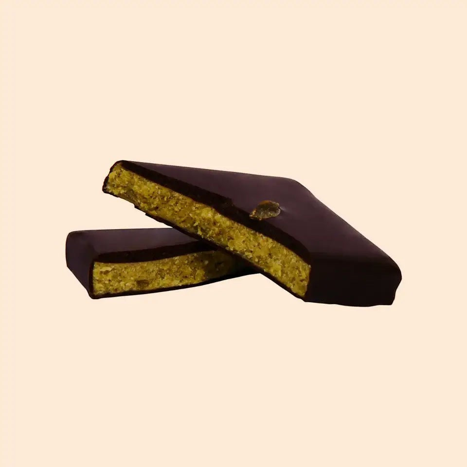Cosmic Dealer dark chocolate bar with a pistachio nut butter center and Lion's Mane mushroom extract, split in half