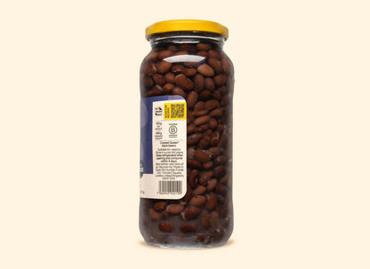Bold Bean Co Queen Black Beans in a 570g glass jar with a yellow lid, showing the product label and dark cooked beans.