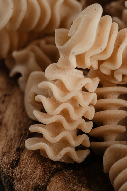 Northern Pasta Co. Radiatori pasta with ruffled edges made from British spelt and wheat semolina on a rustic wooden surface