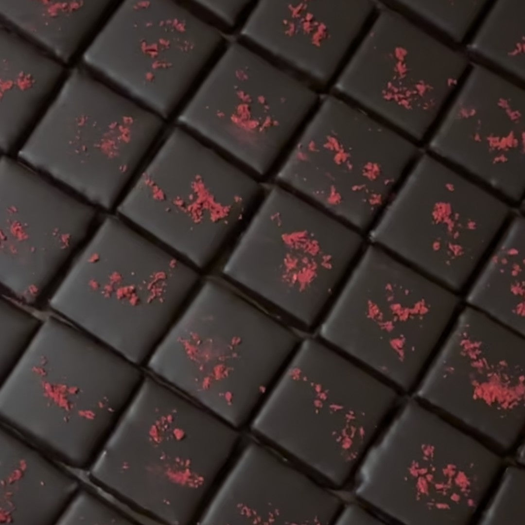 Cosmic Dealer dark chocolate squares with macadamia nut butter filling and a sprinkle of dried raspberry on top