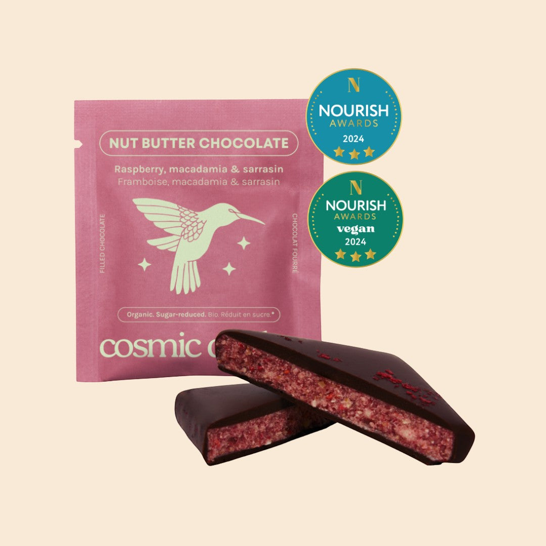 Cosmic Dealer Nut Butter Chocolate with raspberry and macadamia, showing a dark chocolate square split to reveal the filling.
