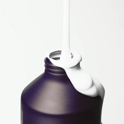Kinfill refillable body wash and lotion duo in a dark purple bottle with white cream pouring over the rim
