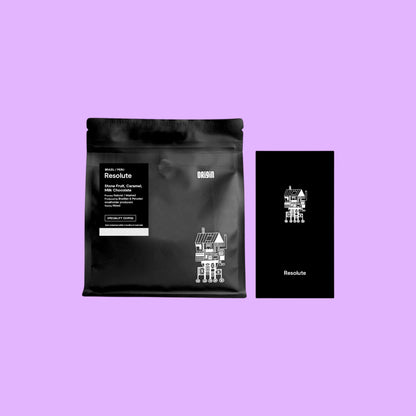 Origin Coffee Resolute whole bean coffee bag in black packaging with white text and graphic design on a light purple background