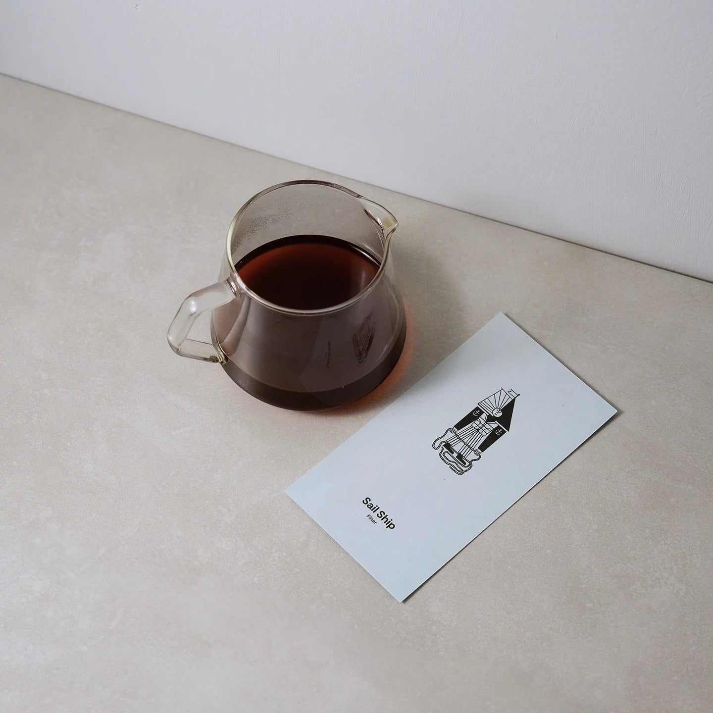 BRiMM Sail Ship filter coffee in a glass carafe next to a branded card with a sailing ship illustration