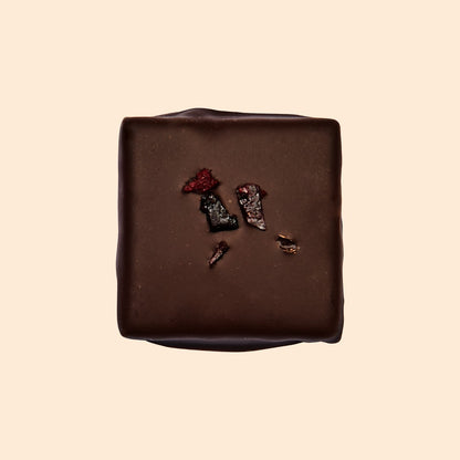 Cosmic Dealer Salty Fig dark chocolate square topped with dried fig pieces, featuring a rich and earthy gourmet finish.
