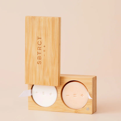 SBTRCT travel skincare set featuring two solid cleansing and moisturizing bars in a sustainable bamboo case.