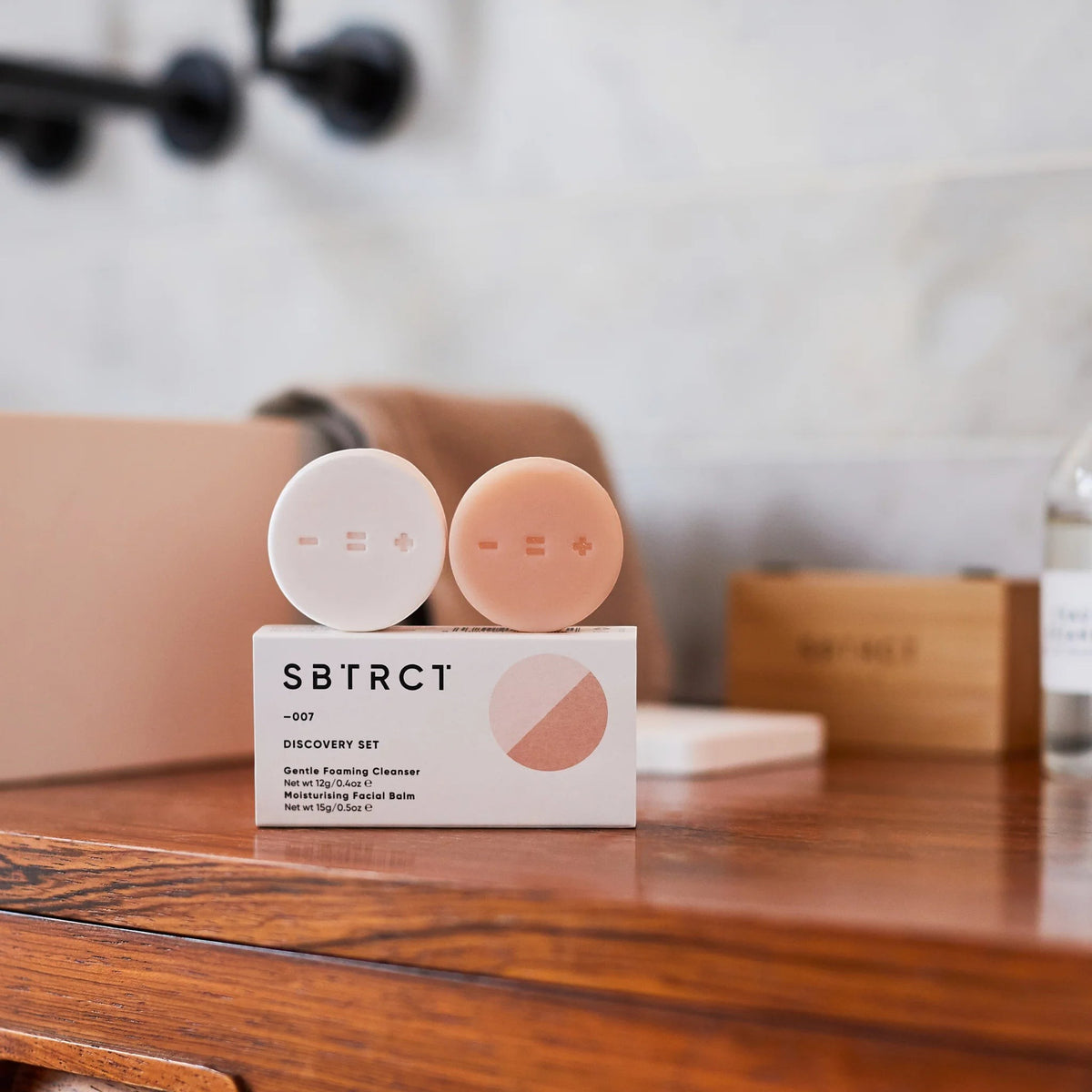 SBTRCT Discovery Travel Minis Cleanse Set featuring solid cleanser and moisturising balm bars on a wooden shelf.
