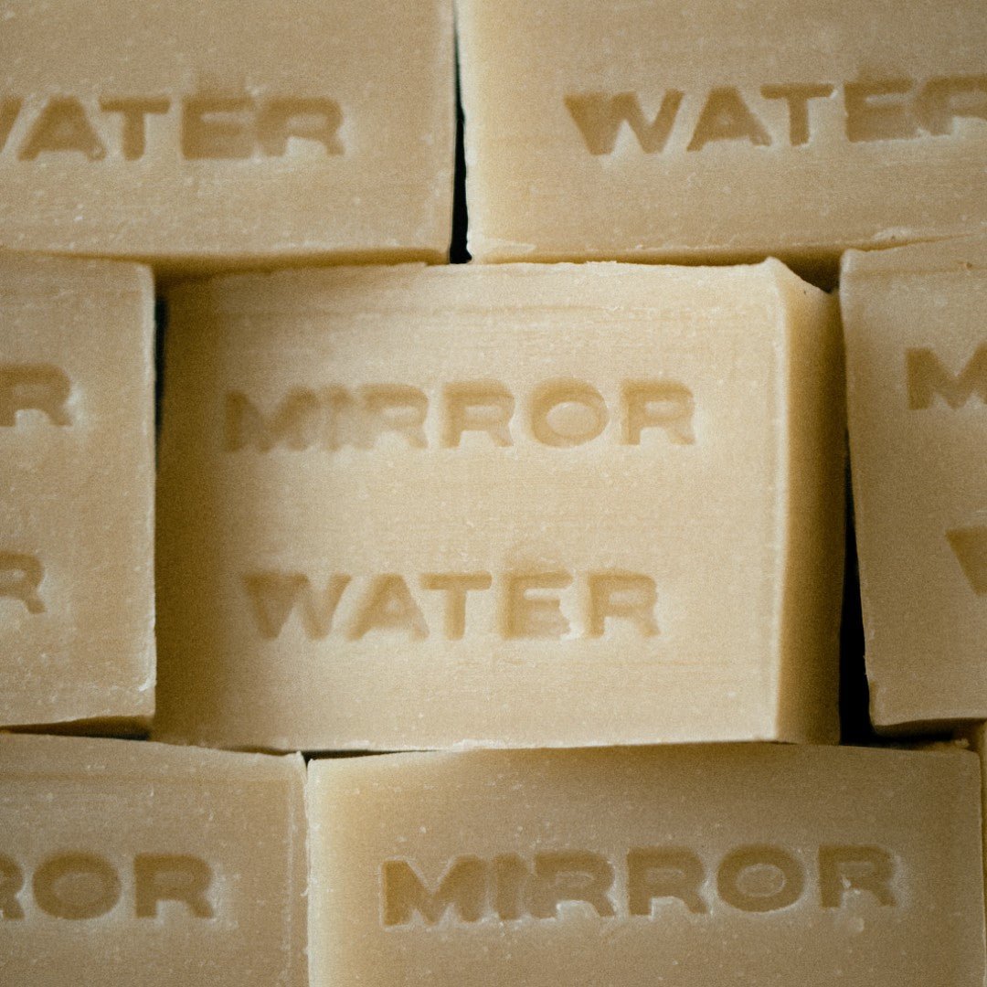 Mirror Water Shea Butter Brick solid face and body cleansing bar with embossed text in a neutral beige tone