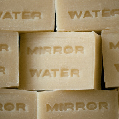 Mirror Water Shea Butter Brick solid face and body cleansing bar with embossed text in a neutral beige tone