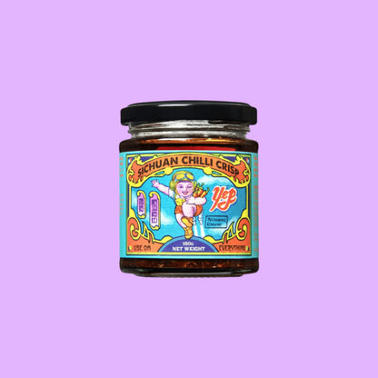 Yep Kitchen Sichuan Chilli Crisp oil in a glass jar with a colourful illustrated label featuring a cartoon character, shown from a different angle.