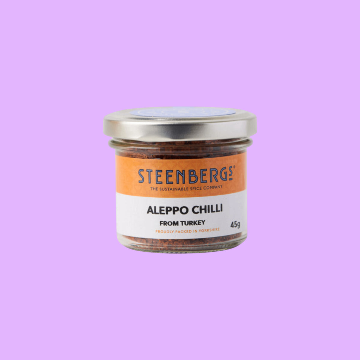Steenbergs organic Aleppo chilli flakes in a recyclable glass jar with a silver lid on a light background.