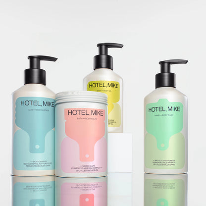 Hotel Mike collection of sustainable skincare products in recyclable aluminium bottles and jars on white display blocks