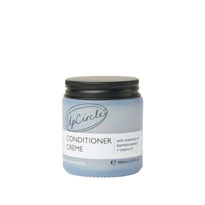 UpCircle conditioner crème in a frosted glass jar with black lid, featuring rosemary oil and bamboo extract.