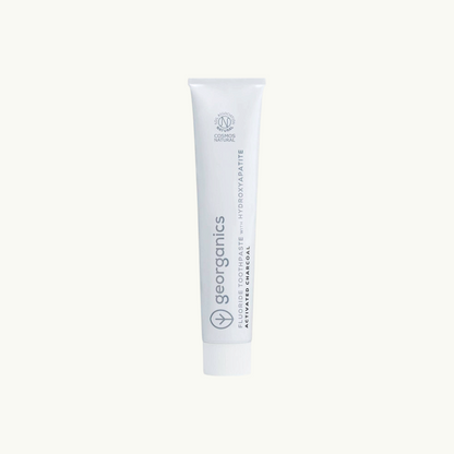 georganics activated charcoal toothpaste tube with hydroxyapatite and fluoride on off-white background