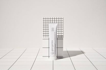 georganics activated charcoal toothpaste tube with hydroxyapatite and fluoride on a white grid background