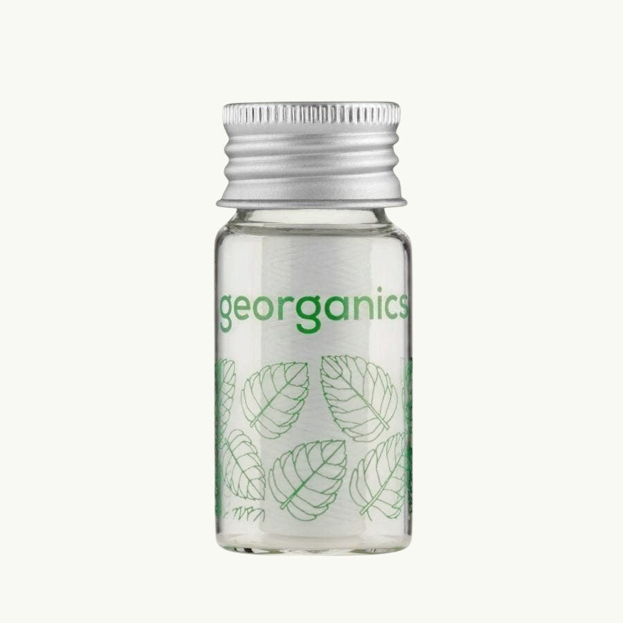 georganics spearmint dental floss in a refillable glass dispenser with an aluminium lid and green leaf print