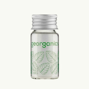 georganics spearmint dental floss in a refillable glass dispenser with an aluminium lid and green leaf print