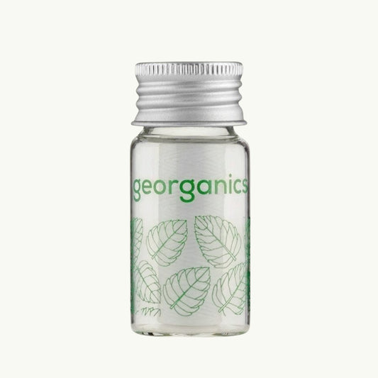 georganics spearmint dental floss in a refillable glass dispenser with an aluminium lid and green leaf print