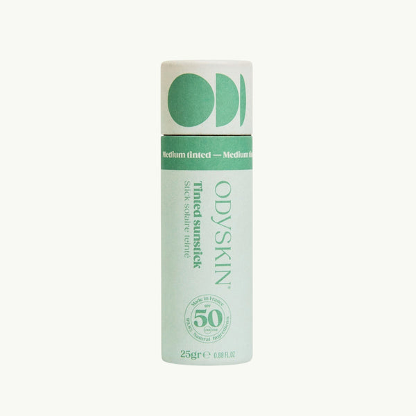 Odyksin SPF 50 tinted mineral sunscreen stick in a light green cardboard tube for easy application on sensitive areas.