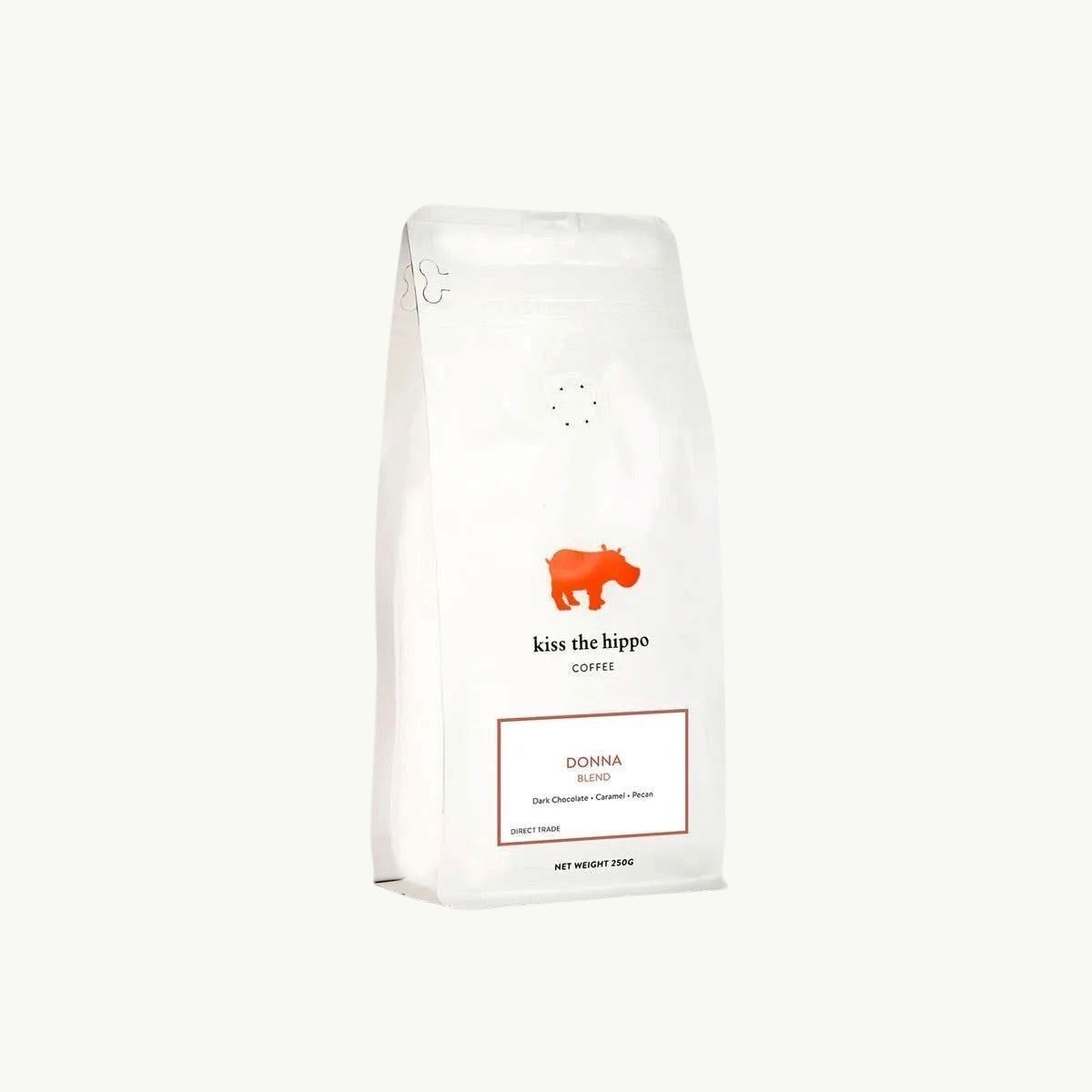 Kiss the Hippo organic whole bean coffee in a white nitrogen-flushed bag featuring a red hippo logo and Donna blend label.