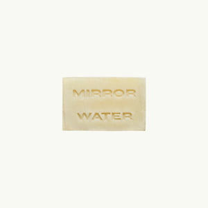Mirror Water Shea Butter Brick solid face and body cleansing bar with embossed text on a neutral background